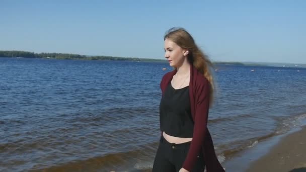Σέξι κορίτσι στην παραλία. Νεαρή γυναίκα πρόκειται να το νερό στην άμμο της παραλίας. — Αρχείο Βίντεο