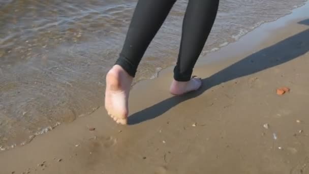 Ноги девушки прогуливаясь по пляжу — стоковое видео