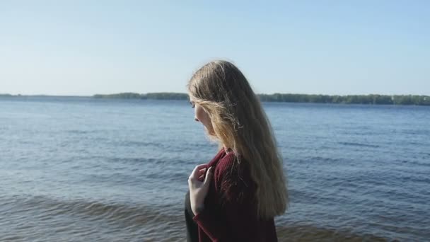 Ung flicka promenader längs stranden av floden kusten — Stockvideo