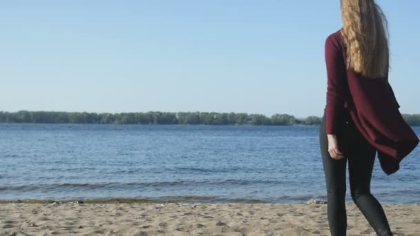 Girl in black goes on the sand to the water — Stock Video