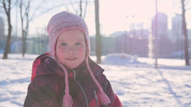 Retrato de una niña en invierno divirtiéndose con nieve — Vídeo de stock