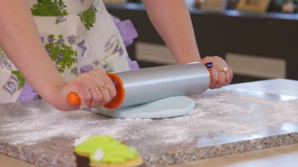 Pâte fraîche roulée à la main féminine sur la table à l'aide d'un rouleau à pâtisserie . — Video