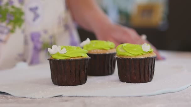 De kok giet suiker cupcakes — Stockvideo