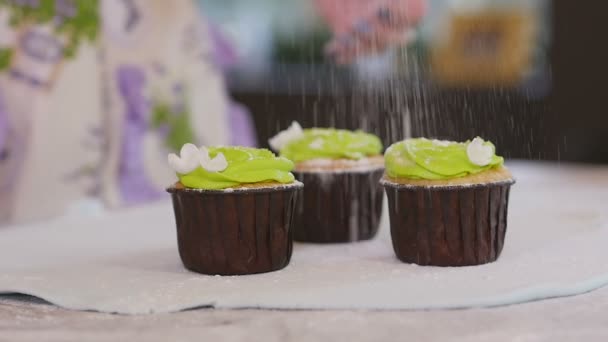 De kok giet suiker cupcakes — Stockvideo