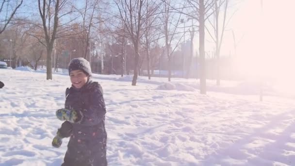 En liten pojke och flicka på vintern kör genom skogen — Stockvideo