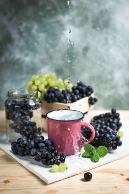 bir ahşap masa ve beyaz tahta üzerinde bir kavanoza üzüm