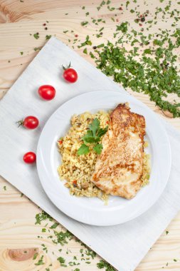 biftek ve pirinç yemek sebze, domates ve yeşillik ahşap bir masa üzerinde bir ışık kesme tahtası üzerinde beyaz bir plaka üzerinde