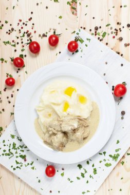 yeşillikleri ile beyaz tabakta et ve beyaz kesme tahtası ahşap bir masa üzerinde kiraz domates ile patates