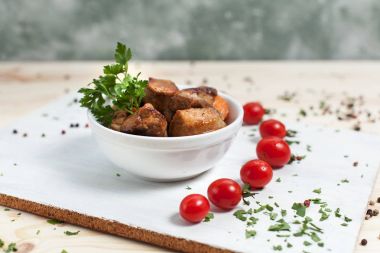 Et yemek yeşil ve kiraz domates ahşap bir masa üzerinde bir beyaz kesme tahtası üzerinde beyaz bir kase