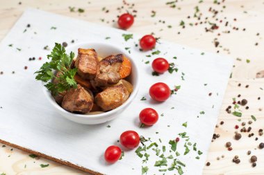 Et yemek yeşil ve kiraz domates ahşap bir masa üzerinde bir beyaz kesme tahtası üzerinde beyaz bir kase