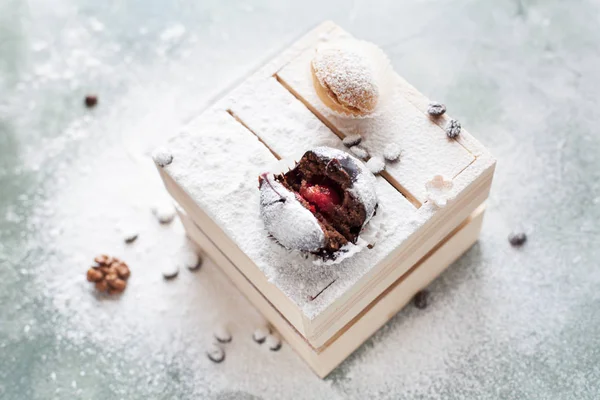 mavi bir arka plan üzerinde kahve çekirdekleri ile ışık ahşap kutusunda kek ile pudra şekeri serpilir