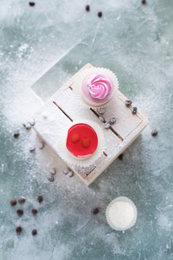 mavi bir arka plan üzerinde kahve çekirdekleri ile ışık ahşap kutusunda kek ile pudra şekeri serpilir