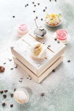 mavi bir arka plan üzerinde kahve çekirdekleri ile ışık ahşap kutusunda kek ile pudra şekeri serpilir