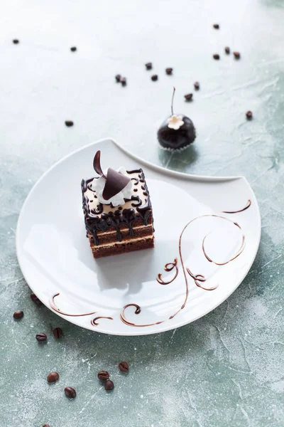 Çikolatalı Pasta krema ve çikolata çilek mavi bir arka plan üzerinde beyaz bir tabakta ile süslenmiş