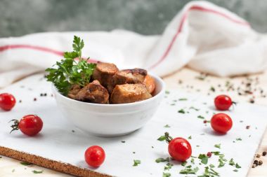 Et yemek yeşil ve kiraz domates ahşap bir masa üzerinde bir beyaz kesme tahtası üzerinde beyaz bir kase