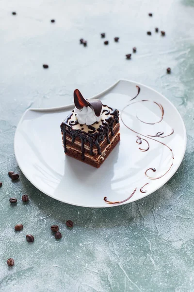 Çikolatalı Pasta krema ve çikolata çilek mavi bir arka plan üzerinde beyaz bir tabakta ile süslenmiş
