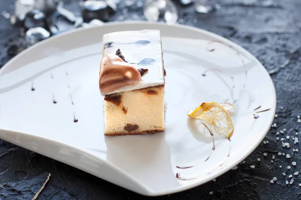 Torta di formaggio con cioccolato su un piatto bianco su sfondo nero — Foto Stock