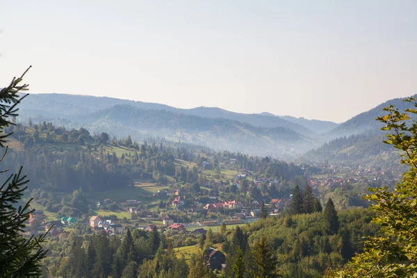 dağlar ve mavi gökyüzü bulutlu fon karşı yaprak dökmeyen ağaçlar