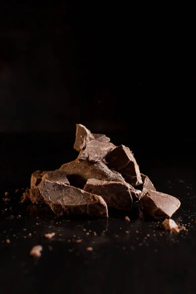 Куски шоколада на черном фоне — стоковое фото