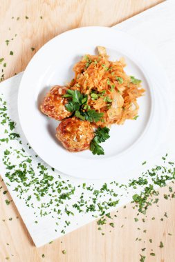 köfte ve ahşap arka plan üzerinde beyaz bir tahta üzerinde beyaz bir tabakta yeşillik ile haşlanmış lahana