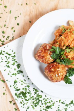 köfte ve ahşap arka plan üzerinde beyaz bir tahta üzerinde beyaz bir tabakta yeşillik ile haşlanmış lahana