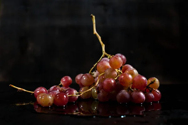 Гроздь красного винограда на чёрном фоне с каплями росы — стоковое фото