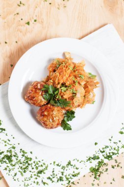 köfte ve ahşap arka plan üzerinde beyaz bir tahta üzerinde beyaz bir tabakta yeşillik ile haşlanmış lahana