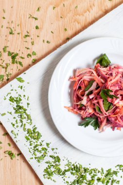 salata sonbahar sebze, lahana, havuç, beyaz kesme tahtası ahşap arka plan üzerinde beyaz bir tabakta yeşillikleri ile