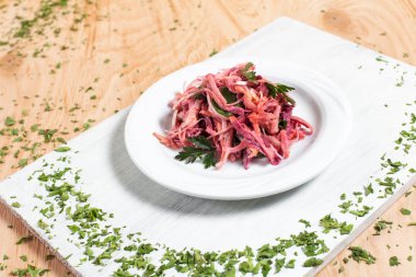 salata sonbahar sebze, lahana, havuç, beyaz kesme tahtası ahşap arka plan üzerinde beyaz bir tabakta yeşillikleri ile