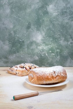 puf böreği berry doldurma ve çikolata ile ahşap arka plan üzerinde beyaz bir tepside pudra şekeri serpilir