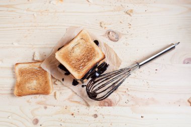 Kağıt ahşap arka plan üzerinde ahşap kesme tahtası üzerinde bir çırpma teli ile çikolata ile döktü bir muz ile tost