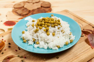 eski bir kızartma tavası sonbahar yaprakları ve biber ile çevrili bir ahşap zemin üzerine ahşap kesme tahtası üzerinde bezelye ile pirinç