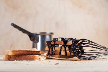 Kağıt ahşap arka plan üzerinde ahşap kesme tahtası üzerinde bir çırpma teli ile çikolata ile döktü bir muz ile tost