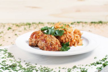 köfte ve ahşap arka plan üzerinde beyaz bir tahta üzerinde beyaz bir tabakta yeşillik ile haşlanmış lahana