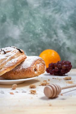 puf böreği berry doldurma ve çikolata, portakal ve üzüm ile ahşap arka plan üzerinde beyaz bir tepside pudra şekeri serpilir