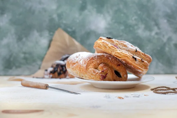 Ciasto francuskie z nadzieniem berry i czekolada posypane cukrem pudrem na talerzu biały na tle drewnianych — Zdjęcie stockowe