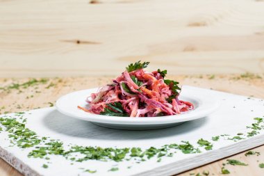 salata sonbahar sebze, lahana, havuç, beyaz kesme tahtası ahşap arka plan üzerinde beyaz bir tabakta yeşillikleri ile