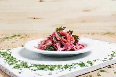 salata sonbahar sebze, lahana, havuç, beyaz kesme tahtası ahşap arka plan üzerinde beyaz bir tabakta yeşillikleri ile