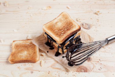 çikolata ile ahşap arka plan üzerinde bir ahşap kesme tahtası üzerinde kağıda döktü bir muz ile tost