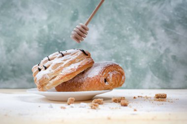 puf böreği berry doldurma ve çikolata ile ahşap arka plan üzerinde beyaz bir tepside pudra şekeri serpilir