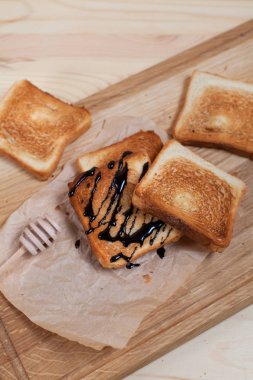 çikolata ile ahşap arka plan üzerinde bir ahşap kesme tahtası üzerinde kağıda döktü bir muz ile tost