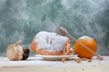 puf böreği berry doldurma ve çikolata, portakal ve üzüm ile ahşap arka plan üzerinde beyaz bir tepside pudra şekeri serpilir