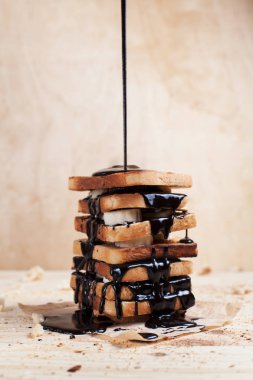 çikolata ile ahşap arka plan üzerinde bir ahşap kesme tahtası üzerinde kağıda döktü bir muz ile tost