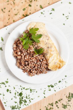 buğday ile ışık ahşap arka plan üzerinde beyaz kesme tahtası üzerinde beyaz bir plaka üzerinde balık otlar ile serpilir