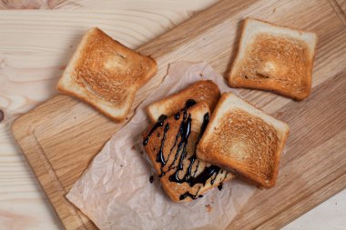 çikolata ile ahşap arka plan üzerinde bir ahşap kesme tahtası üzerinde kağıda döktü bir muz ile tost