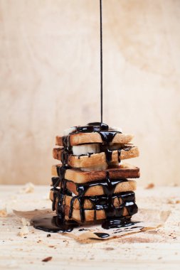 çikolata ile ahşap arka plan üzerinde bir ahşap kesme tahtası üzerinde kağıda döktü bir muz ile tost