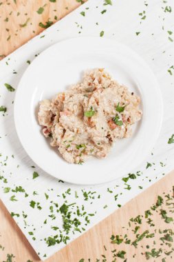 lapa lapa beyaz kesme tahtası hafif ahşap arka plan üzerinde beyaz bir plaka üzerinde otlar ile serpilir