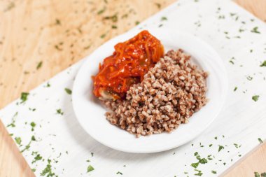 karabuğday balık sosları ile yeşillik serpilir hafif ahşap arka plan üzerinde beyaz kesme tahtası üzerinde beyaz bir tabakta altında