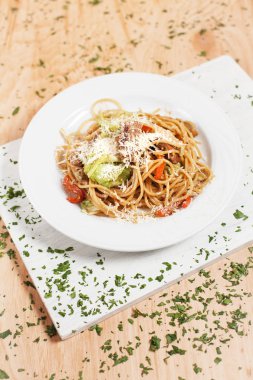 hafif ahşap arka plan üzerinde beyaz kesme tahtası üzerinde beyaz bir tabakta sebze ve et ile makarna otlar ile serpilir