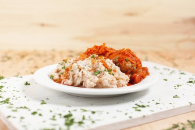 Pearl arpa ile balık sosu hafif ahşap arka plan üzerinde beyaz kesme tahtası üzerinde beyaz bir tabakta altında otlar ile serpilir